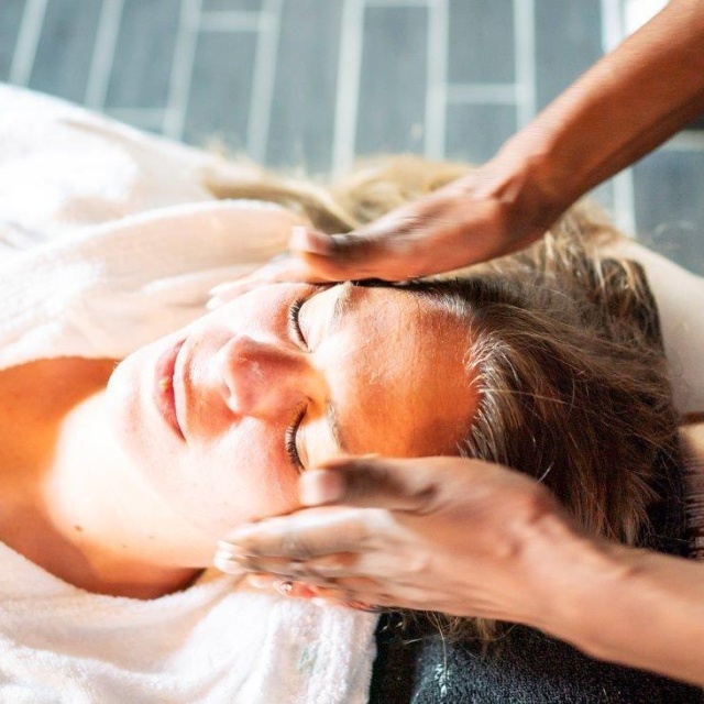 Eine Frau erhält eine Sanddorn-Gesichtsmassage im DünenSpa.