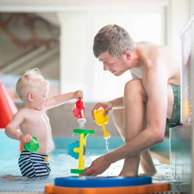 Ein Vater und sein Sohn mit Wasserspielen im InselNBad